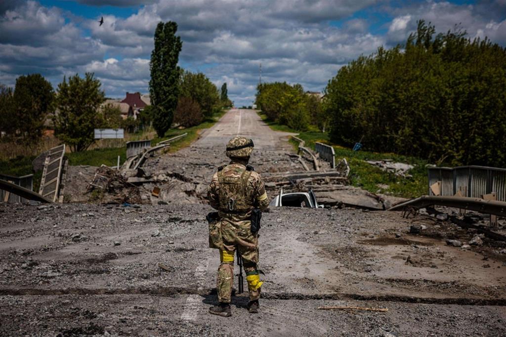 Un militare delle forze speciali ucraine ispeziona un ponte distrutto nel villaggio di Rus'ka Lozova, a nord di Kharkiv, 16 maggio