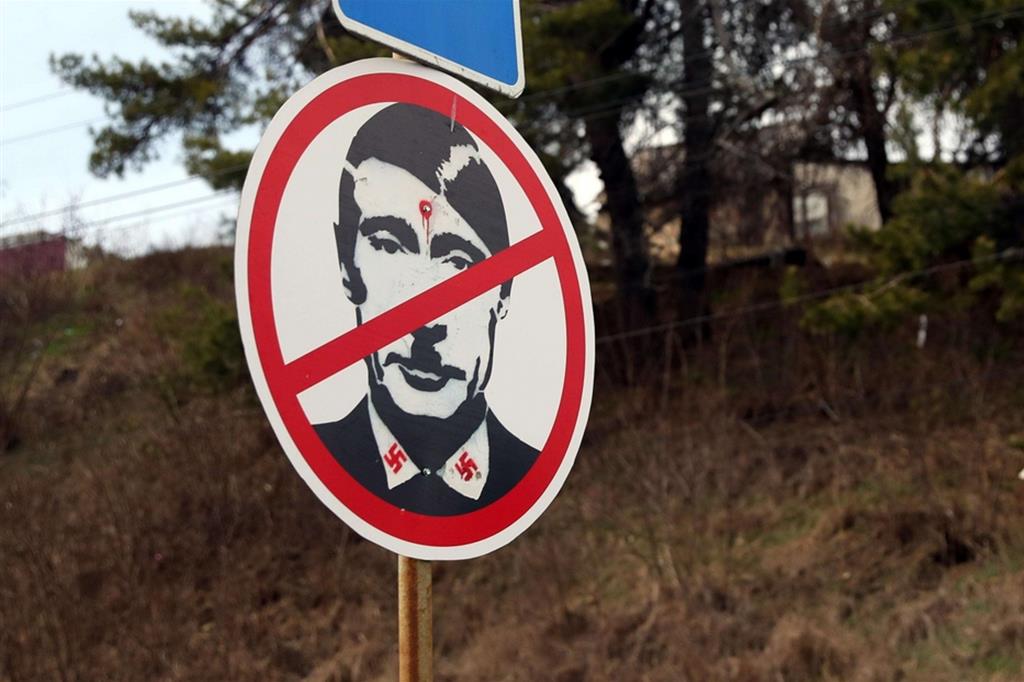 Un cartello stradale con una immagine di Putin con i simboli nazisti in un check point dell'esercito ucraino vicino a Cherkasy - Ansa/EPA/NUNO VEIGA
