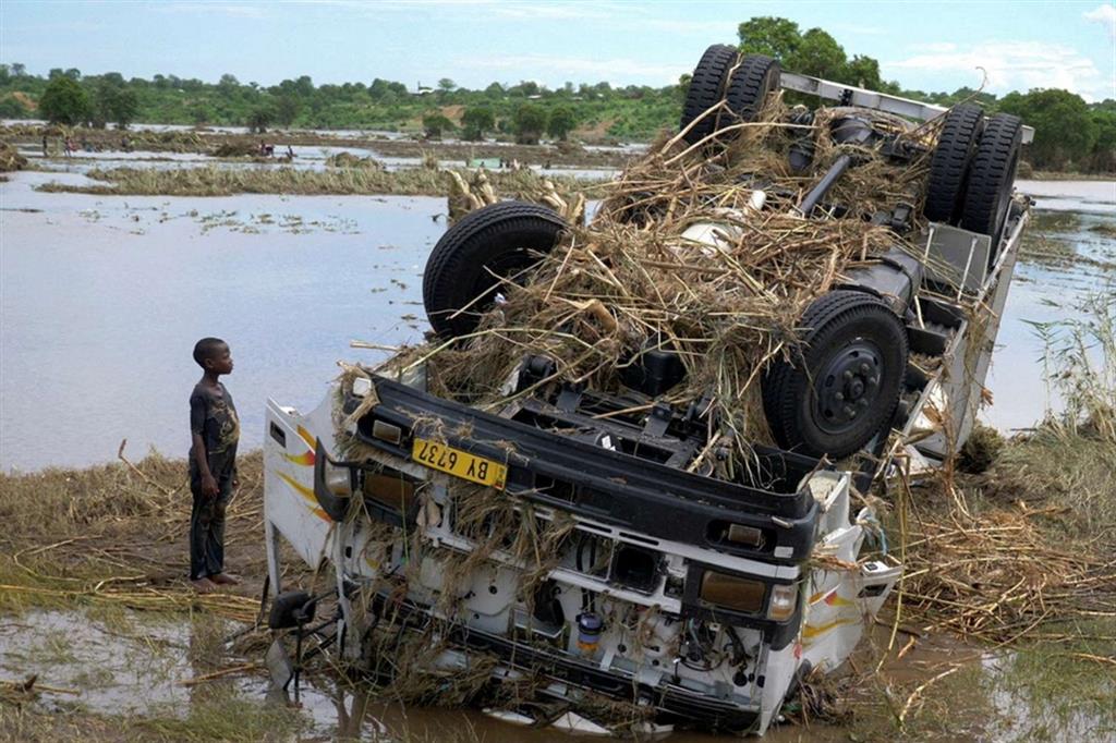 Abitanti del Malawi guardano un furgone distrutto dalla tempesta Ana che ha provocato almeno 86 vittime