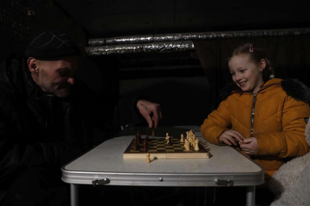 Il sorriso di Yarina, 7 anni, impegnata in una partita a scacchi con il nonno - Ansa