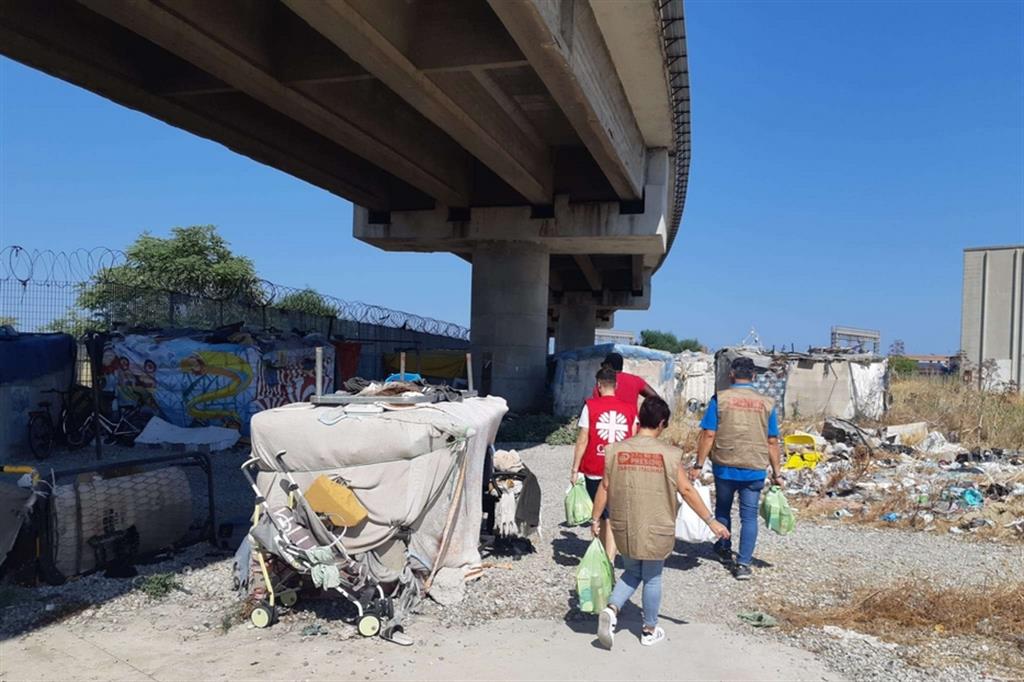 Volontari della Caritas nella baraccopoli sotto il viadotto