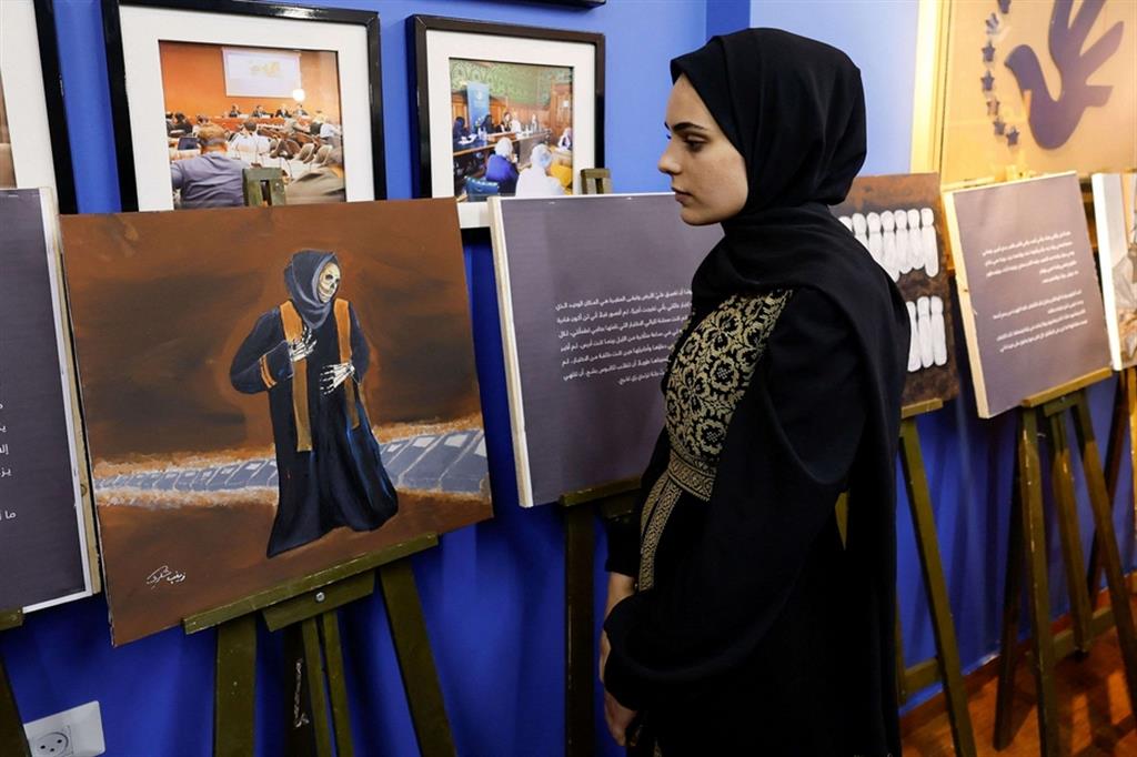L'artista davanti a uno dei dipinti esposti - Reuters