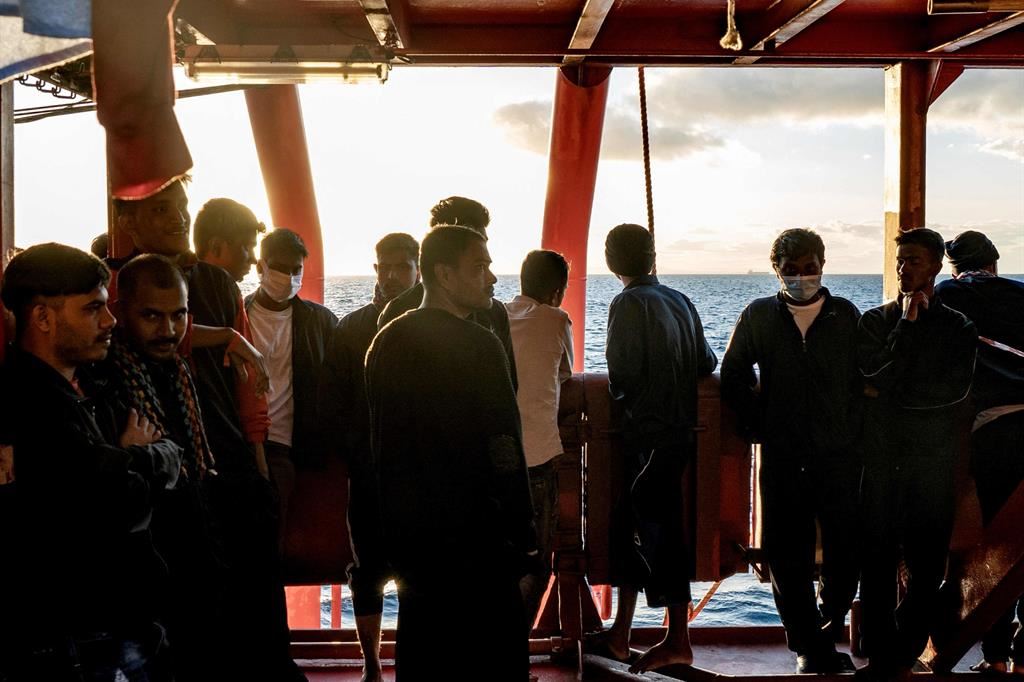 Migranti a bordo della Ocean Viking scrutano l'orizzonte, al largo delle coste siciliane