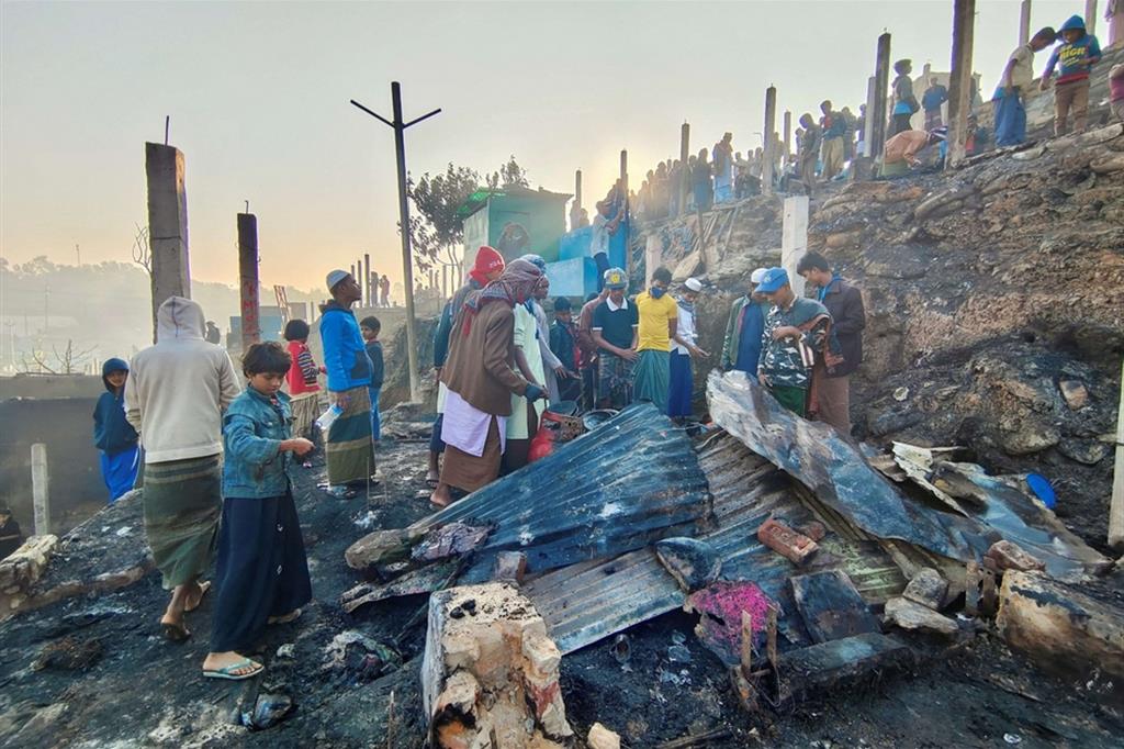 Rifugiati Rohingya si raccolgono vicino alle loro baracche distrutte da un incendio divampato nel Cox's Bazar