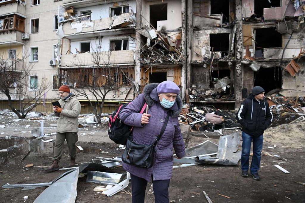 Alcune persone davanti a una palazzina attaccata da un missile a Koshytsa Street, periferia della capitale ucraina Kiev