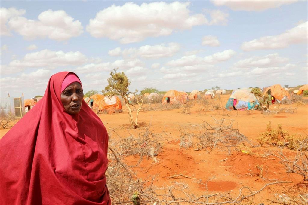 Una donna vicino alle tombe delle sue nipotine, sorelle gemelle, morte di fame nel campo profughi di Kaxareey a Dolo, in Somalia - Reuters