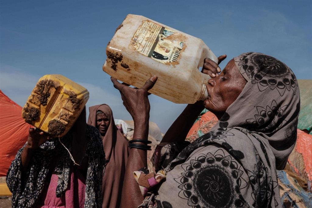 Una donna di 60 anni beve nel punto di raccolta dell'acqua del campo profughi di Muuri a Baidoa, in Somalia - Ansa