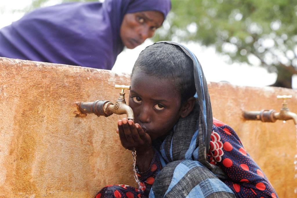 Una bambina di 8 anni beve da una fontana nel campo profughi di Kaxareey a Dolo, in Somalia - Reuters
