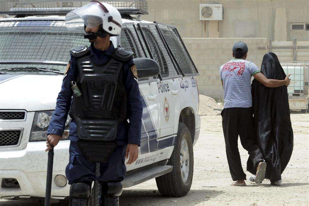 Una donna viene allontanata da un poliziotto durante una manifestazione di protesta in Bahrein