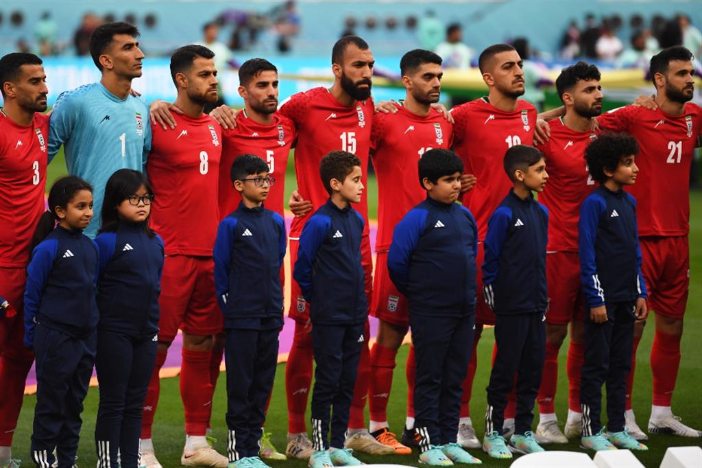 La squadra nazionale, in rosso, in silenzio mentre risuonano le note dell'inno della Repubblica islamica dell'Iran