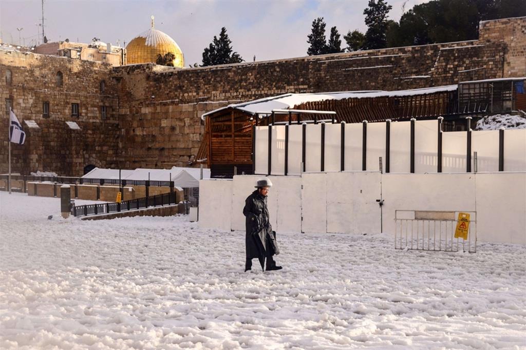 Ebreo ortodosso cammina su una rarissima coltre di neve vicino al Muro del Pianto nella Città Vecchia di Gerusalemme - Reuters