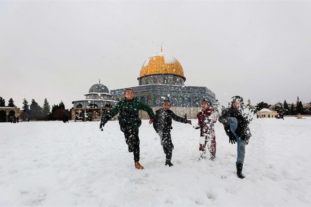 Bambini giocano a palle di neve vicino alla Cupola della Roccia nella Città Vecchia di Gerusalemme dopo una rarissima nevicata - Reuters