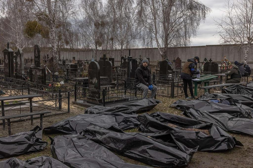 I corpi delle persone uccise sono stati portati al cimitero dove funzionari pubblici cercano di dare a ciascuno in nome - EPA/ANSA/ROMAN PILIPEY