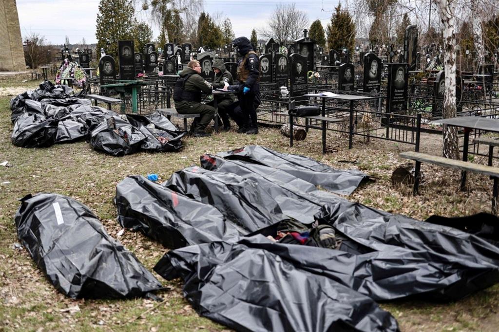 Un funzionario identifica l'identità dei corpi delle vittime ritrovate a Bucha, raccolte al cimitero cittadino - EPA/ANSA/ROMAN PILIPEY