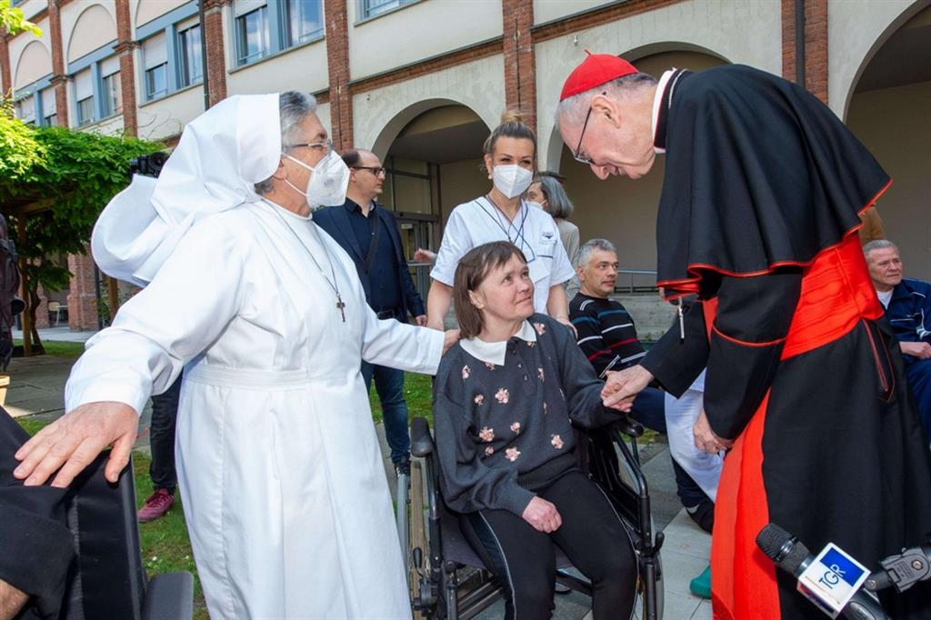 Il cardinale Parolin stringe le mani ad Ala, una profuga ucraina disabile accolta al Cottolengo di Torino