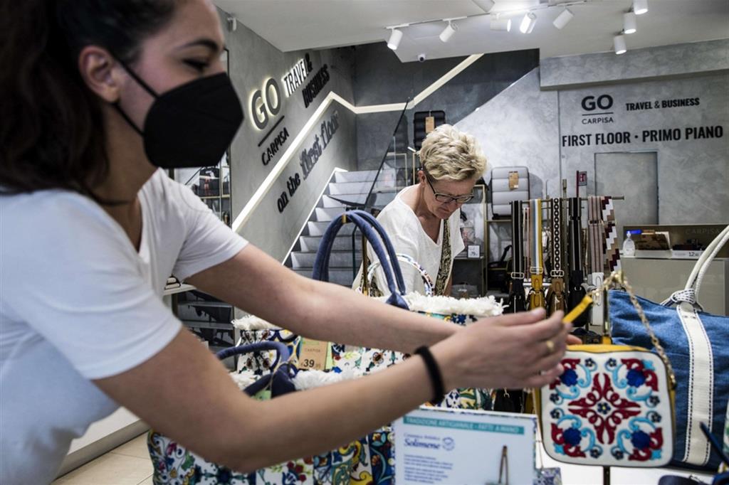 Una commessa indossa la mascherina in un negozio nel centro di Roma