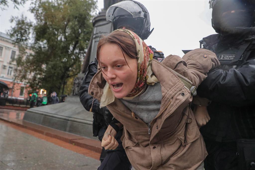 Poliziotti russi trattengono una donna durante una manifestazione contro la mobilitazione militare