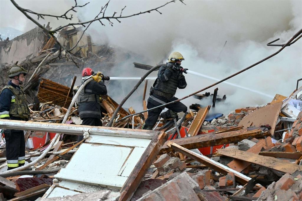 Pompieri al lavoro dopo che un missile ha distrutto un'abitazione alla periferia di Kharkiv