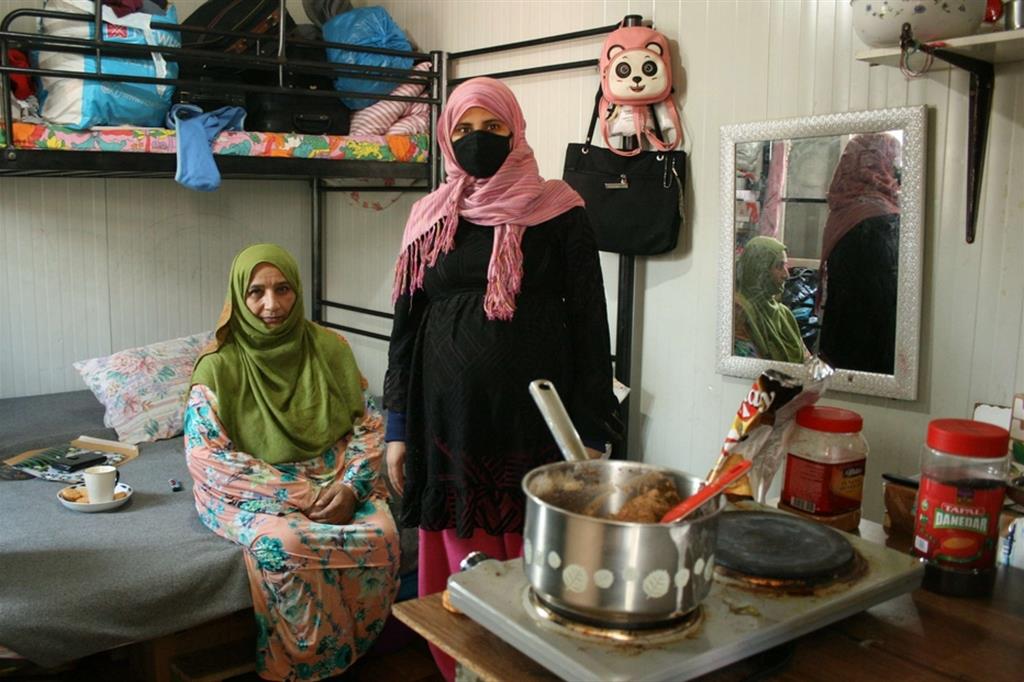 Abida (a destra), madre di tre figli e di nuovo in attesa, nel container che divide con la vicina Kulsoom