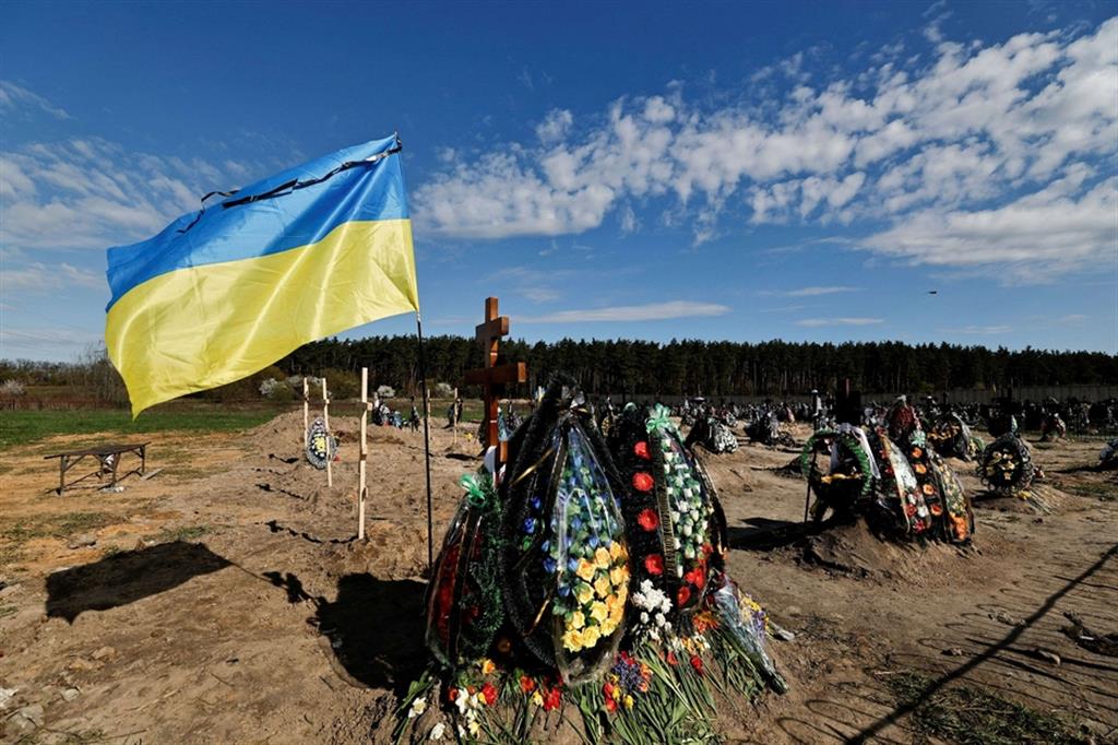 La bandiera dell'Ucraina sopra una tomba nel cimitero di Bucha