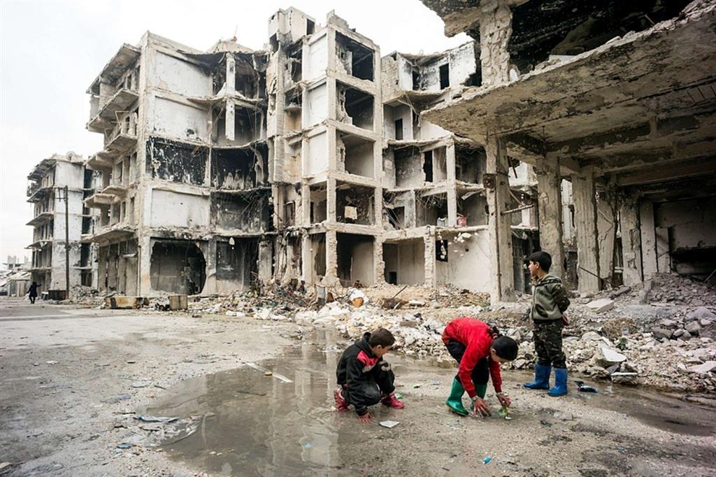 Bimbi giocano ad Aleppo, in Siria, tra le macerie dei palazzi devastati nell'assedio