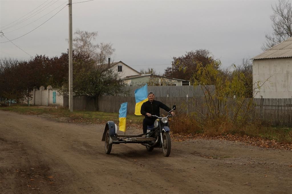 Yurii Nevolchuk, insegnante, sventola la bandiera ucraina sulla sua moto a Blahodatne, liberata dai russi, nella regione di Kherson, 11 novembre