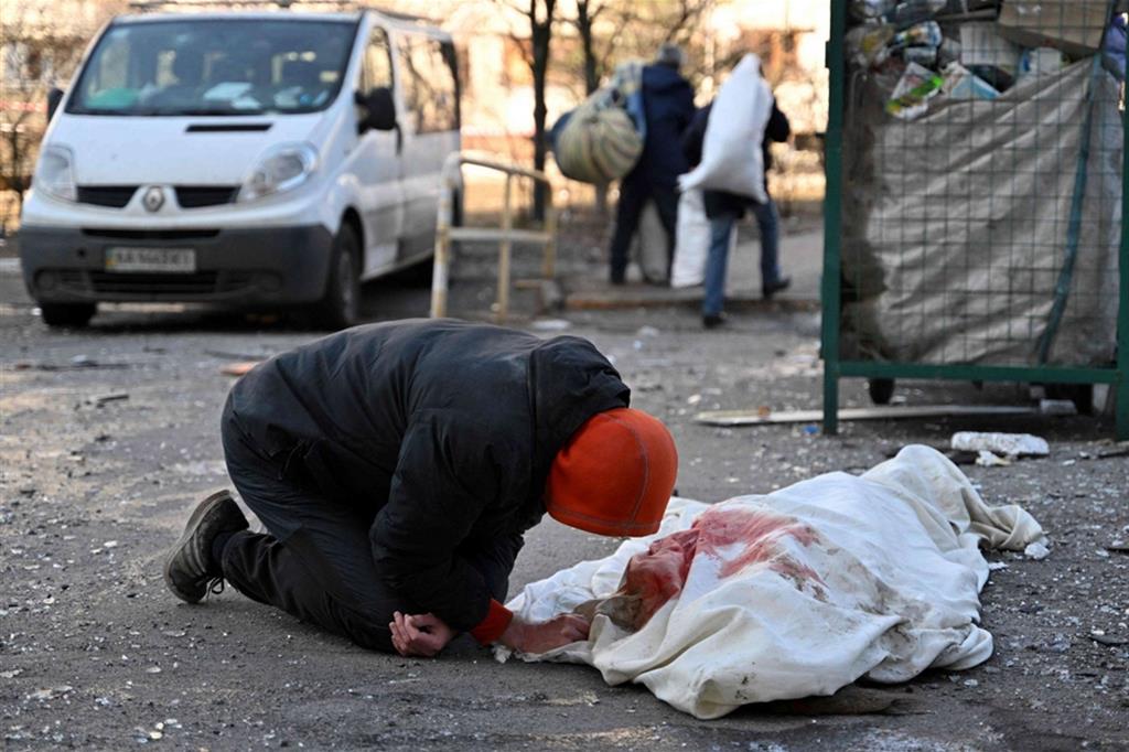 Una donna piange una vittima di un bombardamento a Kiev