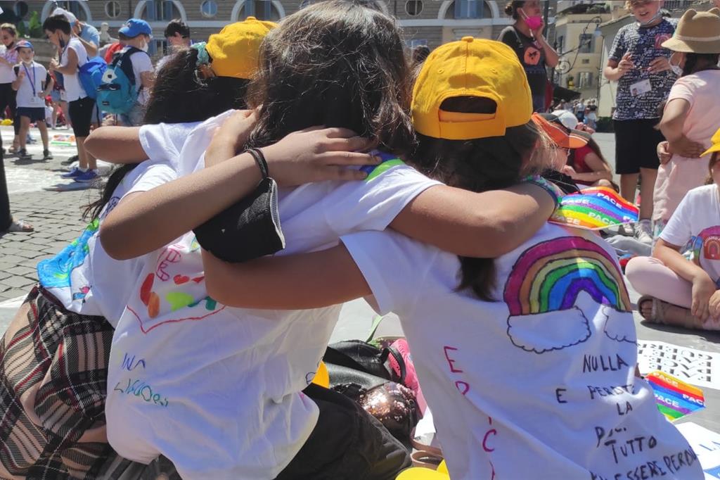 Tre bambine di quarta elementare seguono il flash mob abbracciate