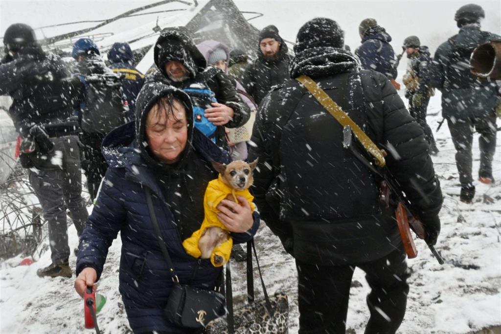 Una signora fugge da Irpin: il suo cagnolino protetto dal freddo con una copertina. La città nell'Oblast di Kiev è tra quelle più devastate dai bombardamenti - Ansa