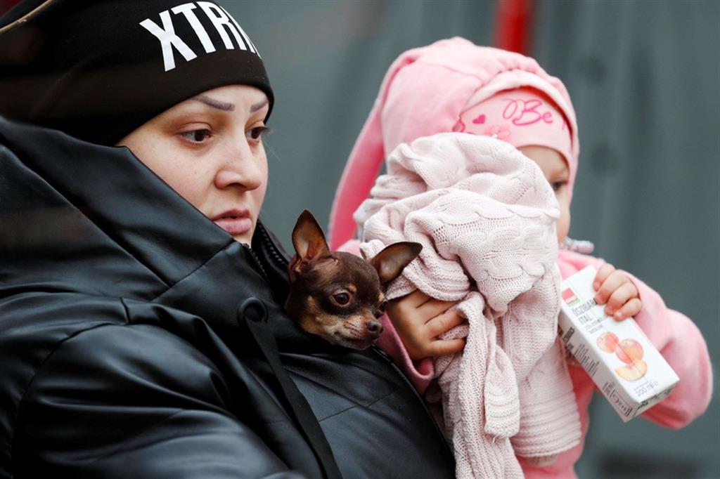 In fuga dall'Ucraina con il bimbo in braccio e il cagnolino nel giubbotto - Reuters