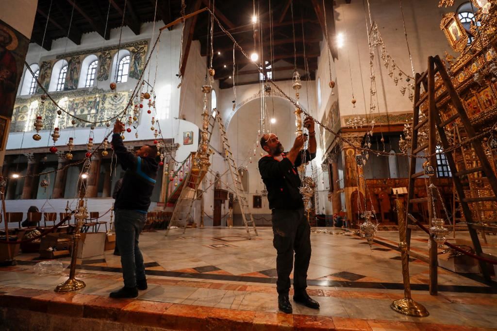 Tecnici al lavoro per completare gli addobbi nella Basilica della Natività a Betlemme