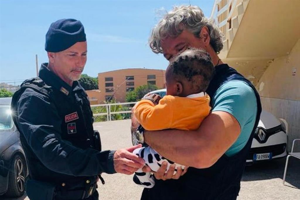 Il piccolo Ismaele di 6 mesi, che ha perso la mamma nel naufragio di un barchino, coccolato dai poliziotti in servizio nell'hotspot di Lampedusa