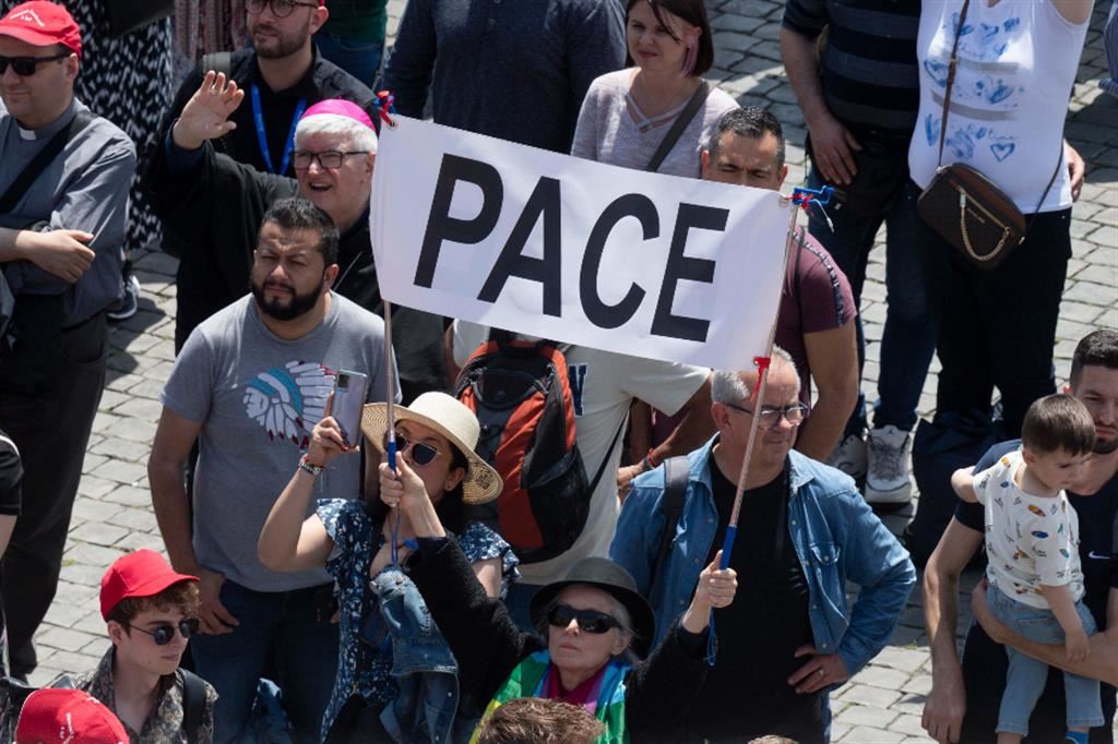Fedeli in piazza San Pietro, al Regina Coeli del Papa, con uno striscione che invoca la pace
