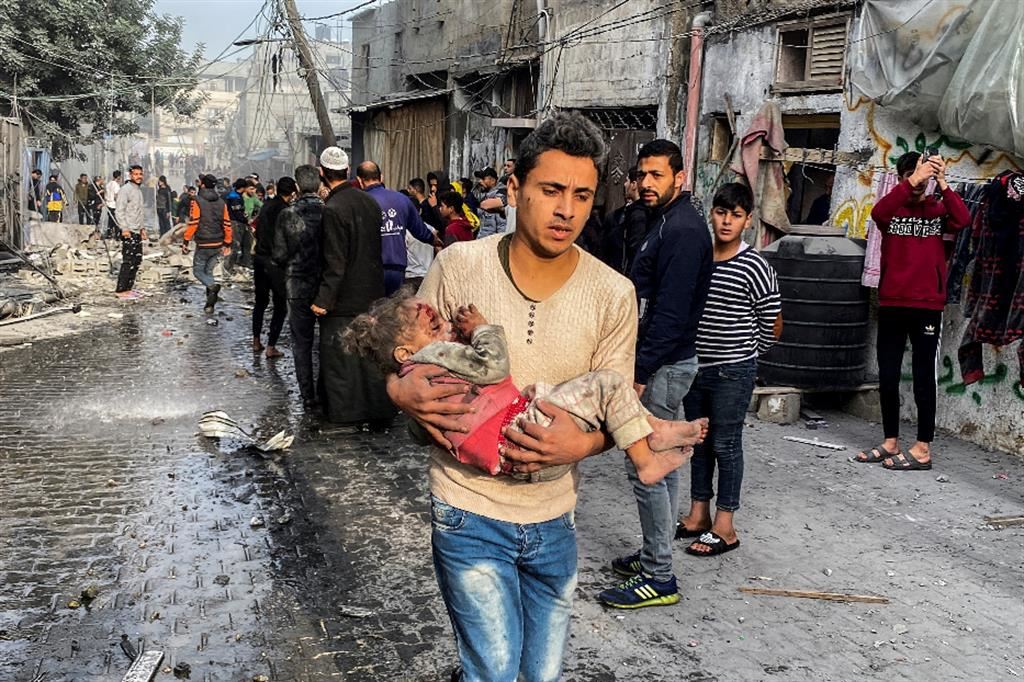 Un palestinese trasporta un bimbo ferito in seguito a un attacco contro una casa, dopo la scadenza della tregua temporanea tra Hamas e Israele