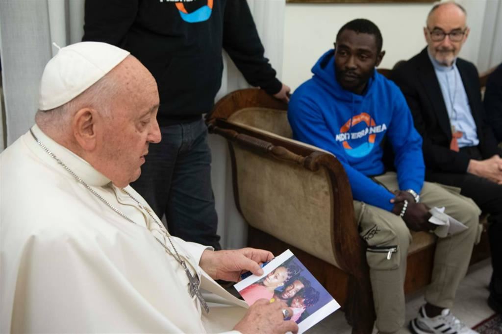 Un momento dell'incontro tra Pato e il Papa, che tiene in mano la fotografia della moglie e della figlia del giovane migrante