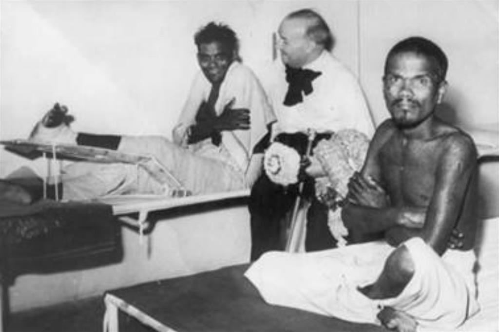 Raoul Follereau tra due malati di lebbra in India