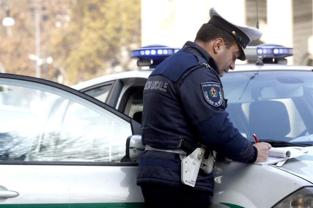 Un agente della polizia locale di Milano mentre fa una multa