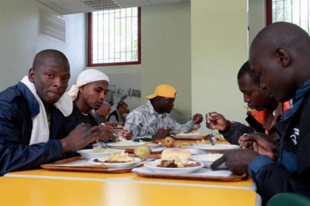 Migranti a una mensa Caritas