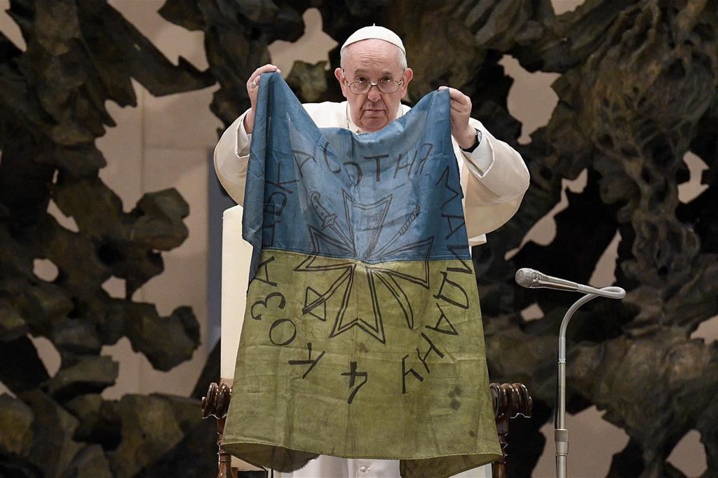 Il Papa con la bandiera dell'Ucraina portata dalla città devastata di Bucha nell'udienza del 6 aprile 2022