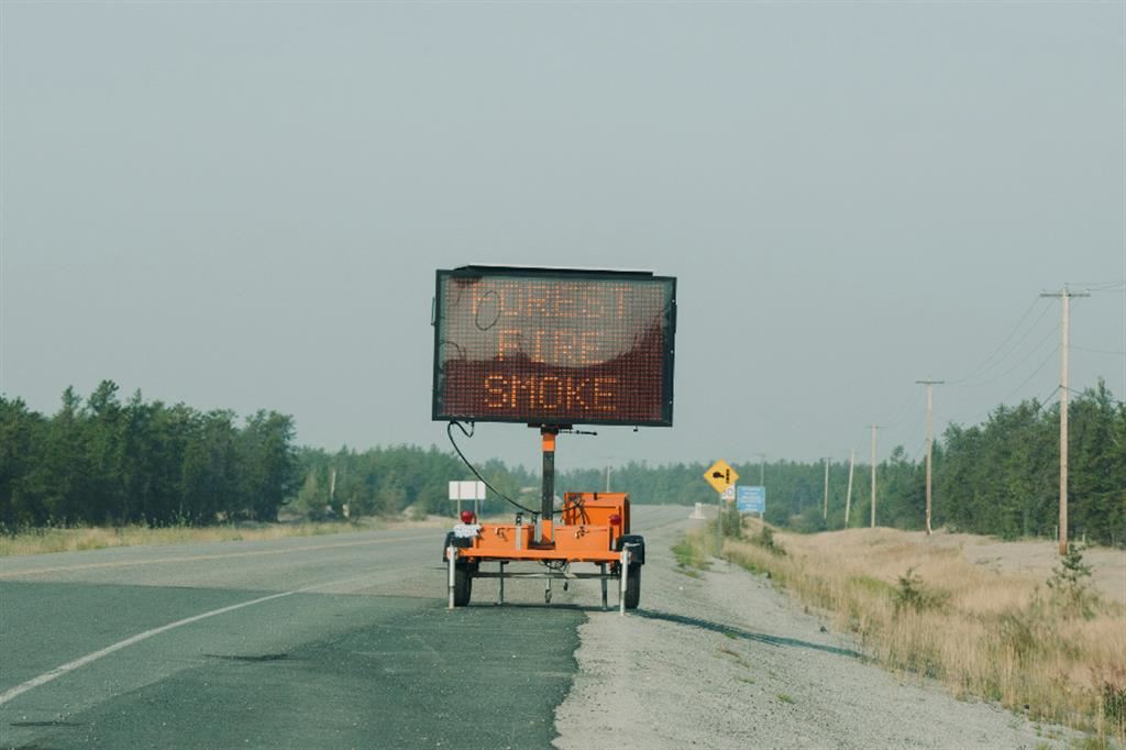 Un cartello lungo la strada avverte: incendi boschivi, attenzione al fumo - Reuters