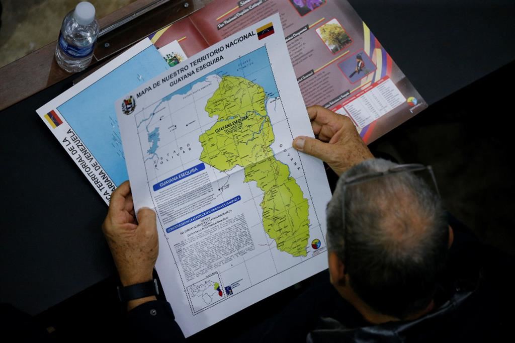 Un membro del Parlamento venezuelano consulta la mappa del territorio che Caracas vuole annettere