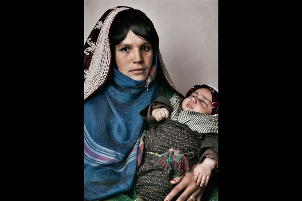 Sfollata interna col suo bambino. Vive in un campo nel mezzo di un deserto di sabbia e pietra senza nessuna assistenza da parte del governo afghano. Nel campo non ci sono le scuole, i bagni, l’ospedale e non c’è lavoro. Gli sfollati mangiano solo pane. Beneficiaria di un progetto di sviluppo rurale dell’ex GVC (Gruppo di Volontariato Civile), ora WeWorld-GVC. Distretto di Pashtun Zargun, Provincia di Herat, Afghanistan