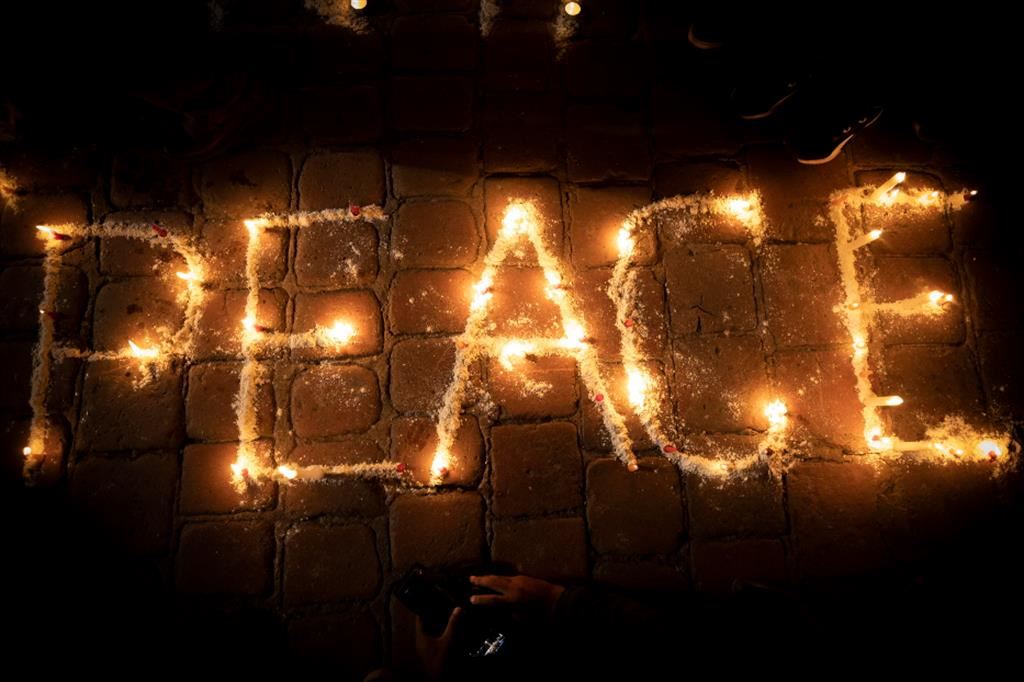 La parola "pace" scritta con le candele in Nepal a  una veglia di preghiera per i cittadini nepalesi uccisi nell'attacco di Hamas a Israele