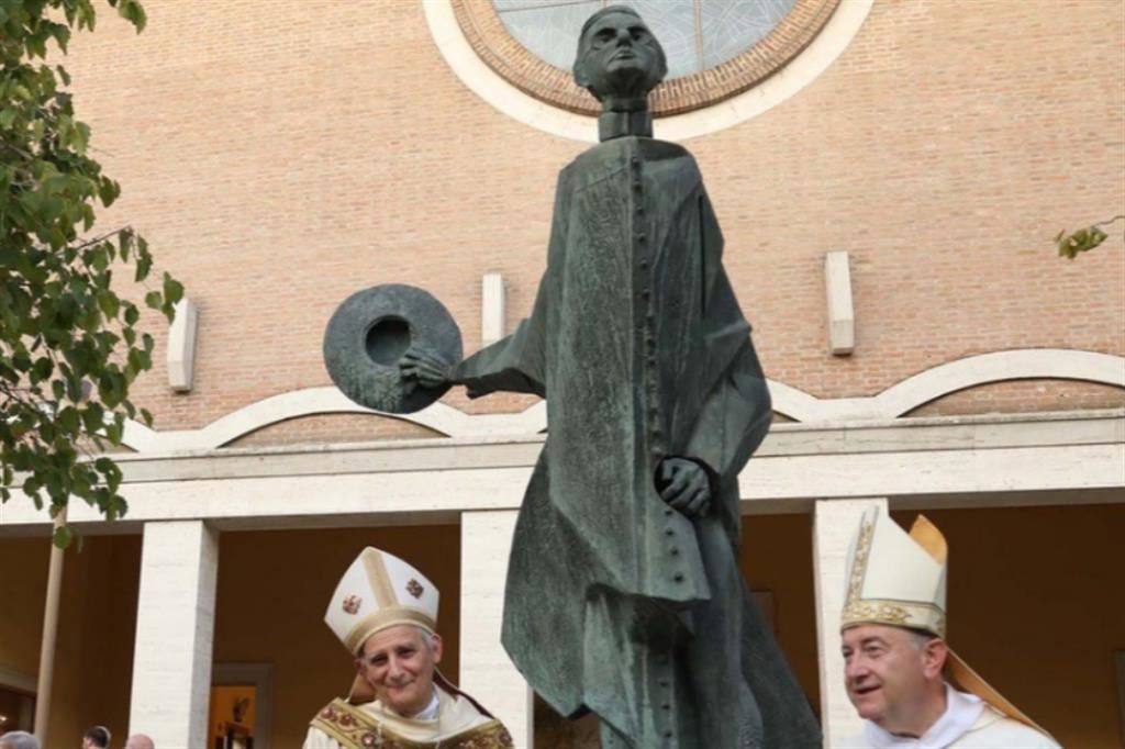 Il cardinale Zuppi e l'arcivescovo Ghizzoni davanti alla statua dedicata a don Minzoni