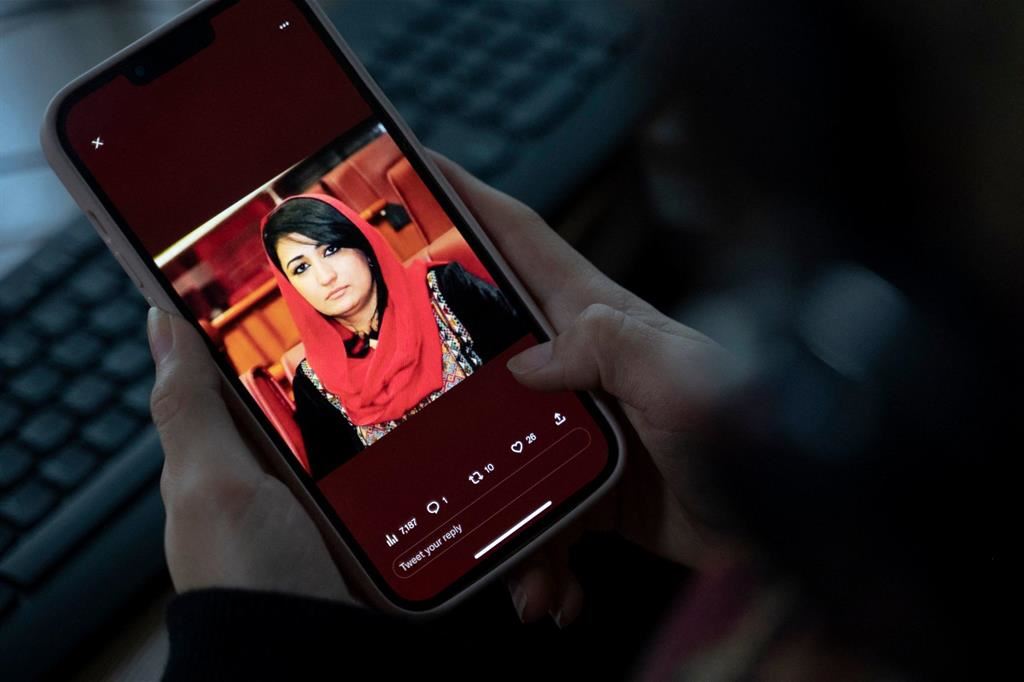 Una donna guarda sul telefonino la foto di Mursal Nabizada uccisa da colpi di spari a Kabul
