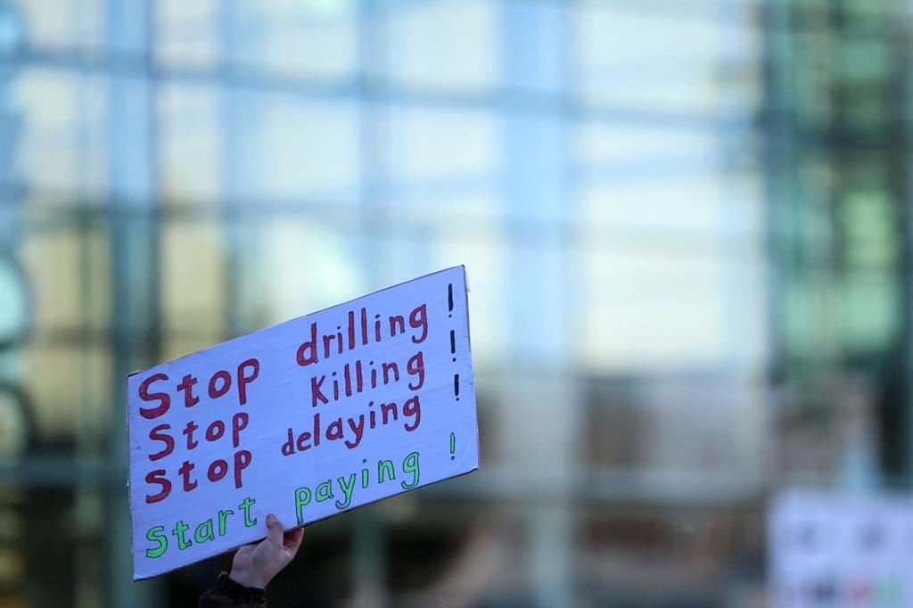 Un cartello durante una protesta per il clima a Londra chiede: sto alle perforazioni, alle uccisioni, ai rinvii, iniziate a pagare