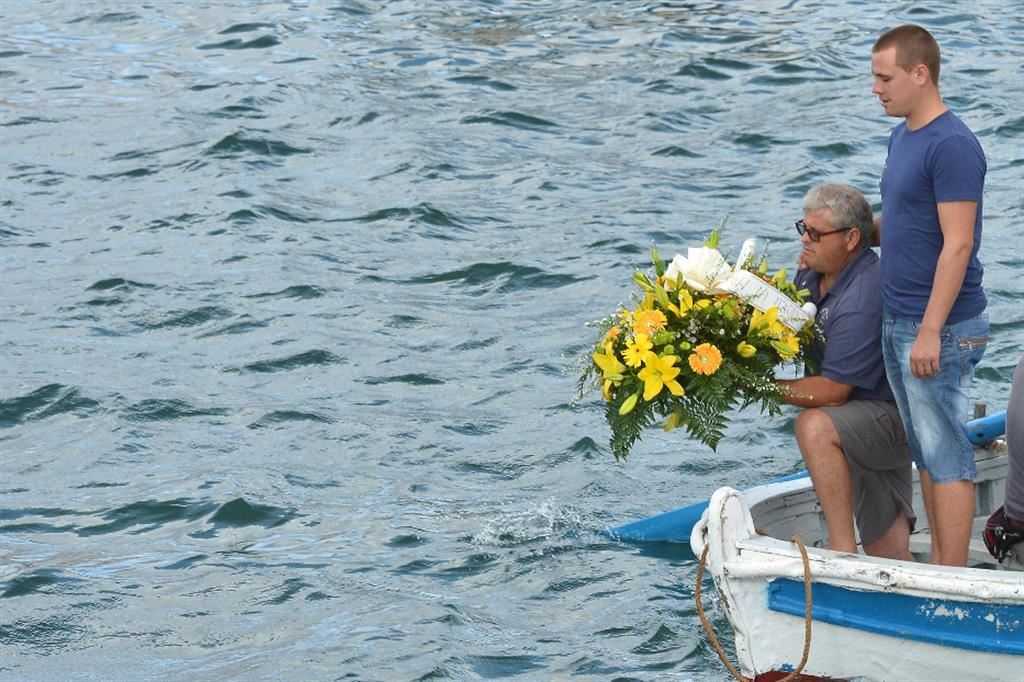 Un pescatore di Lampedusa getta una coron in acqua
