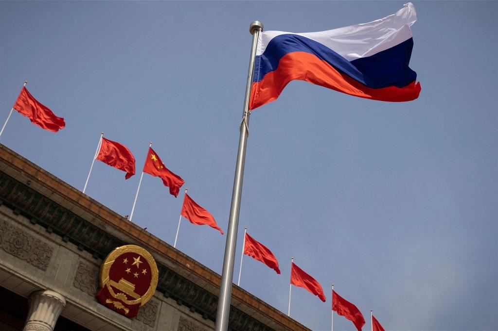 La bandiera russa sventola davanti alla Grande Sala del Popolo di Pechino, in occasione della visita del primo ministro russo Mikhail Mishustin lo scorso magggio
