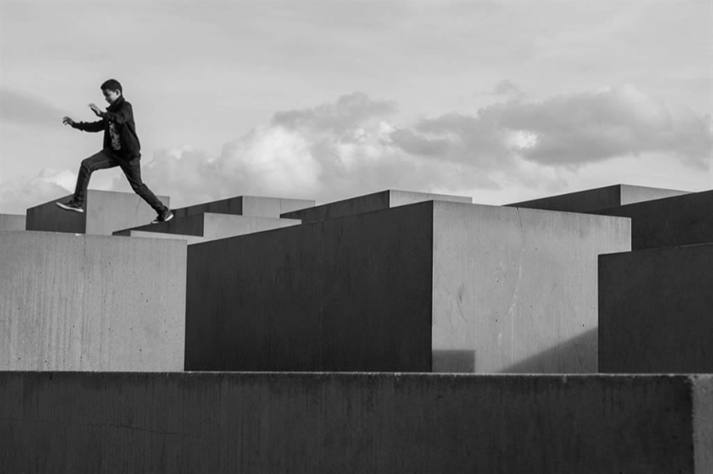 Un ragazzo salta sulle stele del Memoriale dell’Olocausto di Berlino