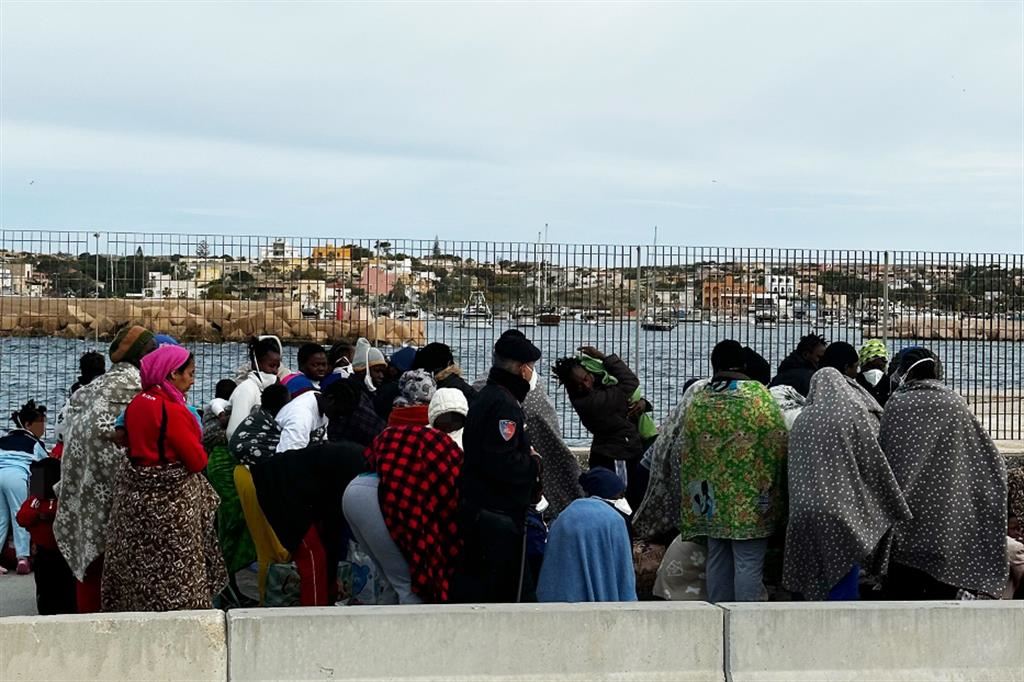 Migranti nel porto di Lampedusa in attesa di essere imbarcati sulla nave per Porto Empedocle